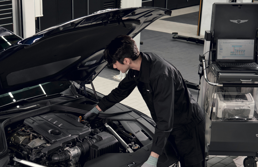 genesis mechanic working under the hood of a vehicle